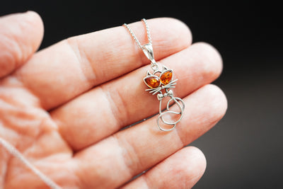Delicate silver cat pendant.