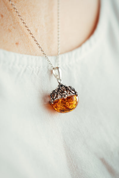 Round, filigree, pendant with Baltic amber.