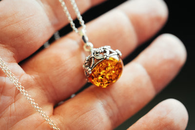 Round, filigree, pendant with Baltic amber.